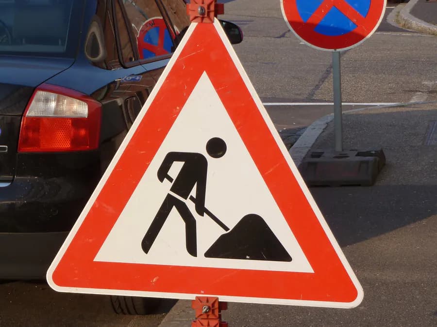 Verkehrszeichen 123 „Arbeitsstelle“ auf Standrohr mit Fußplatte am Fahrbahnrand